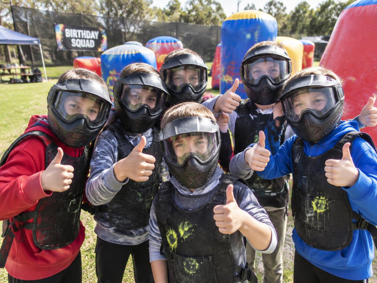 Group of children in protective face masks giving a thumbs up at a Gel Blaster birthday party